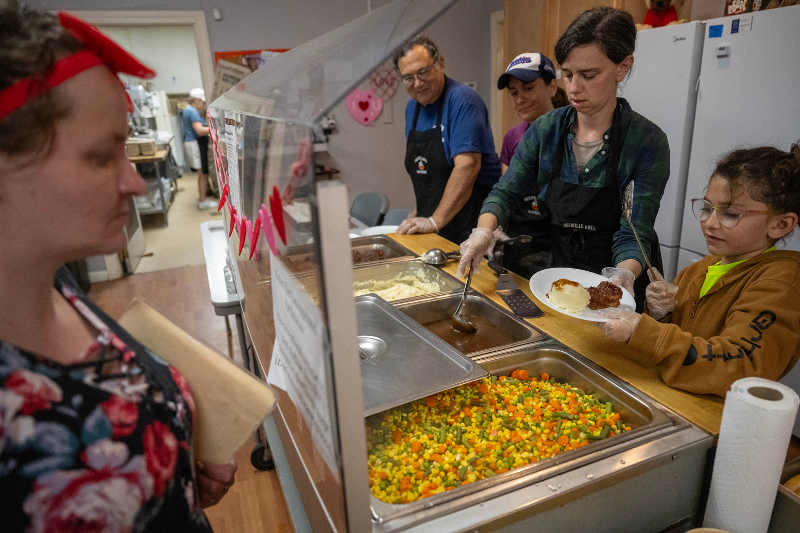 Volunteers serving another volunteer